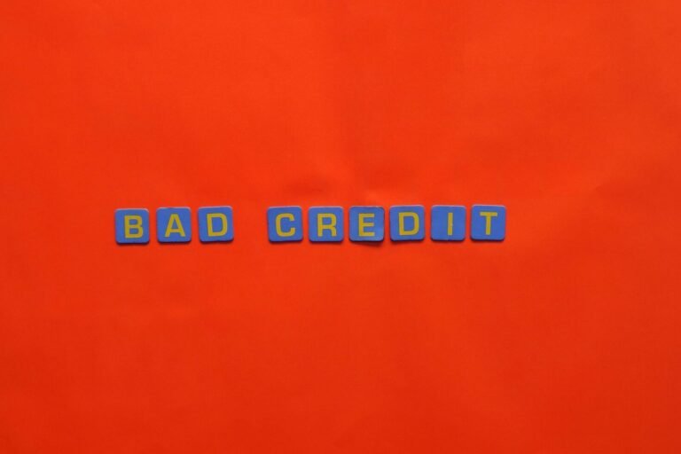 Blue letter blocks spelling 'Bad Credit' on an orange background.
